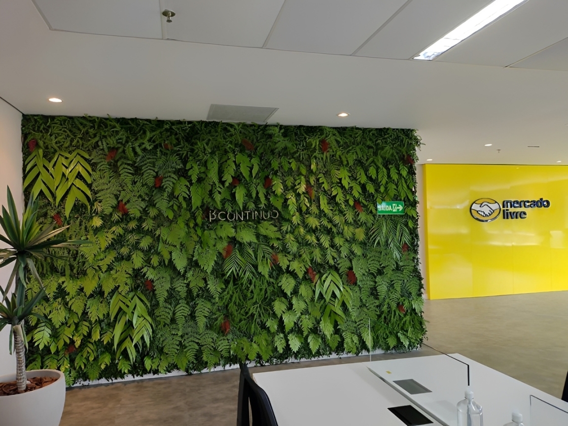 Case escritório corporativo com jardim vertical natural exuberante cobrindo parede inteira, plantas vivas tropicais em tons de verde intenso, ambiente interno iluminado com móveis modernos, fotografia realista de interiores corporativos de alto padrão
